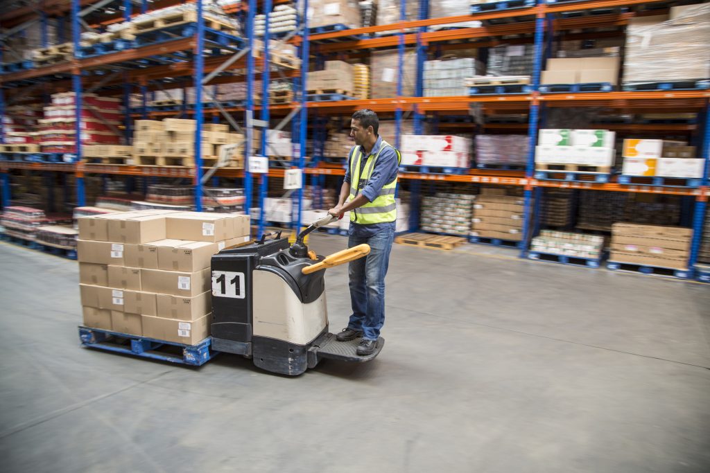 Worker inside a food distribution warehouse, pallet stacking, factory automation